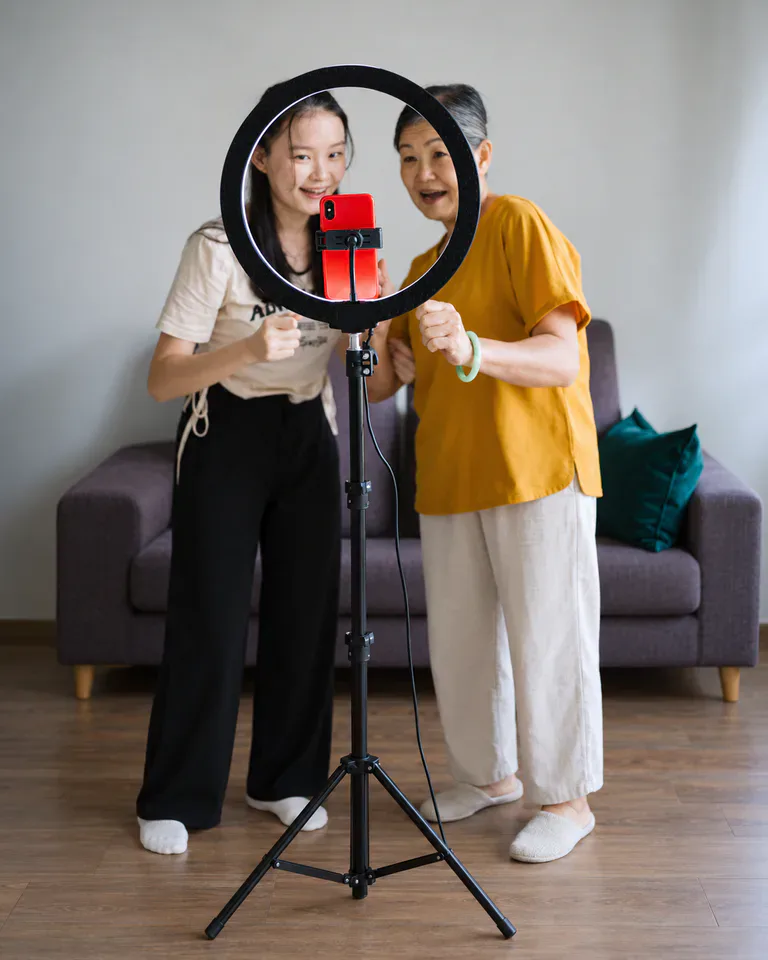 Hai phụ nữ cười bên vòng đèn chụp ảnh điện thoại