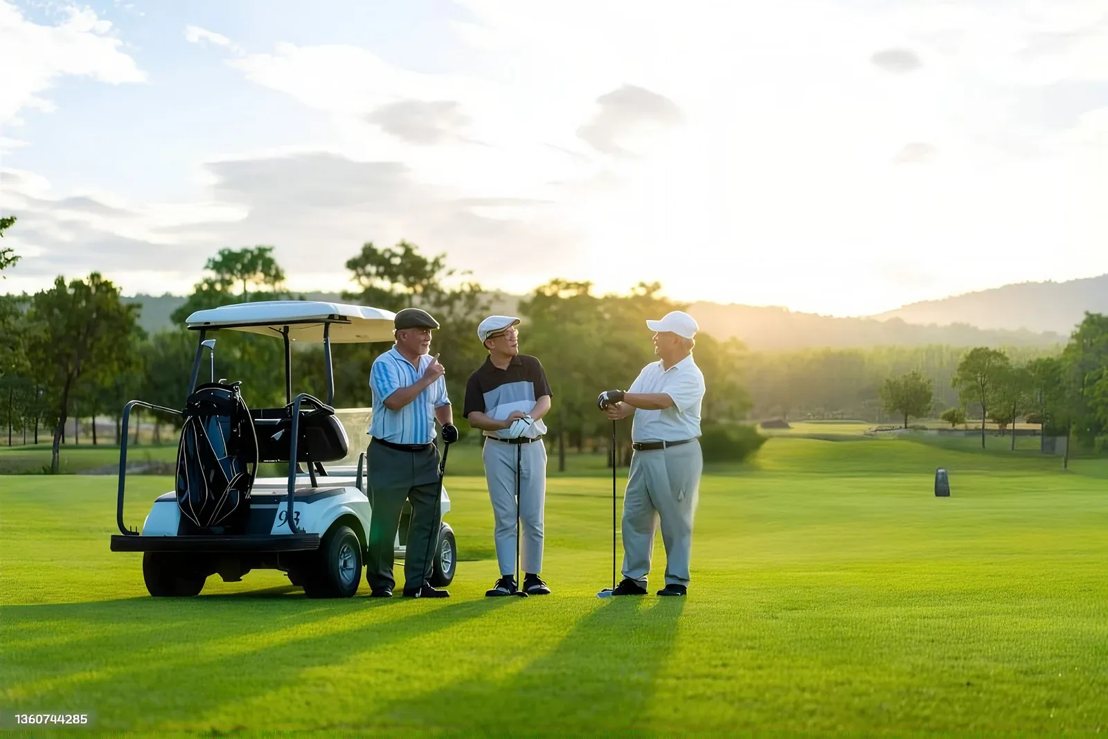 Ba ông cụ trò chuyện bên xe golf trên sân cỏ lúc hoàng hôn